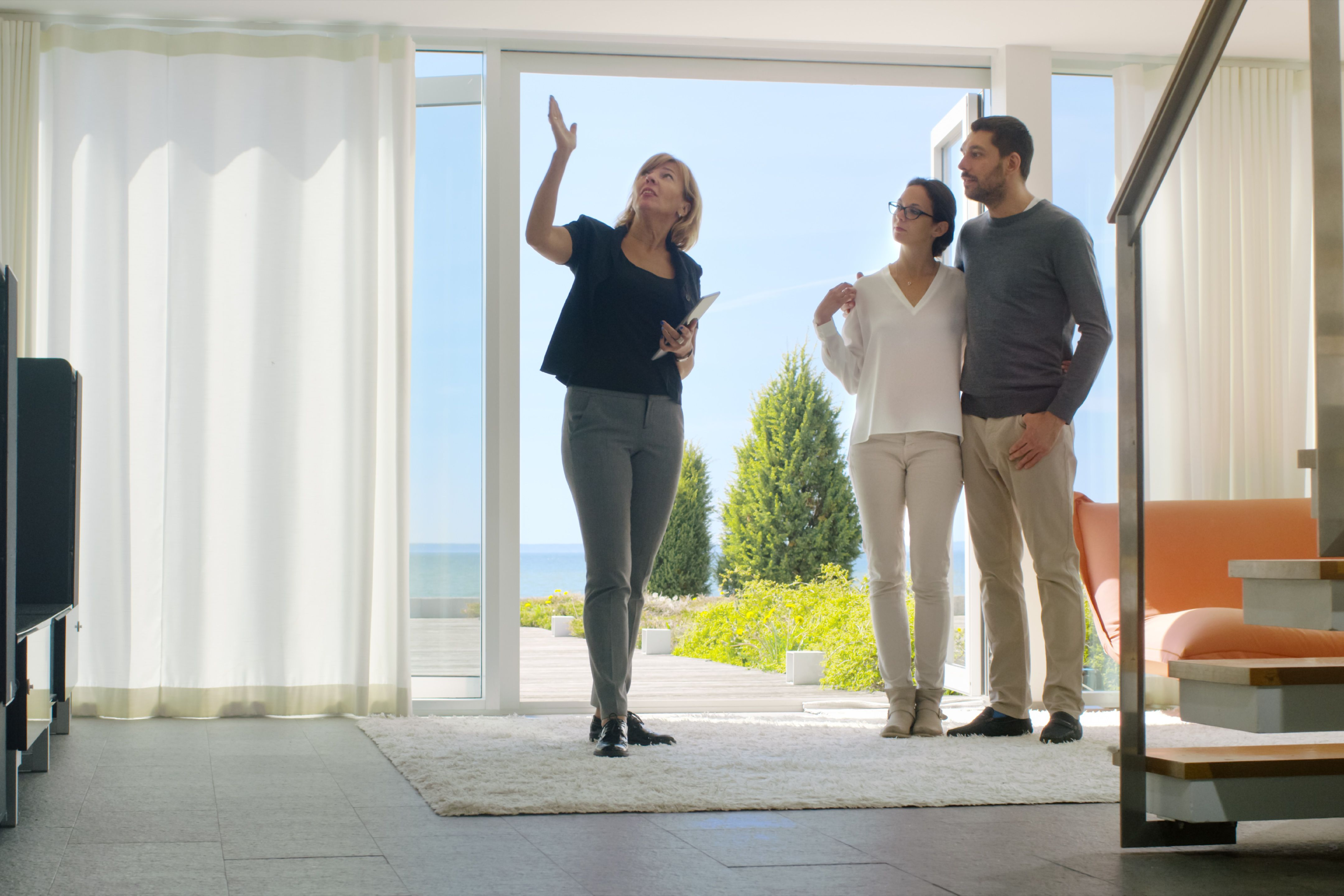An estate agent showing a couple around a property.